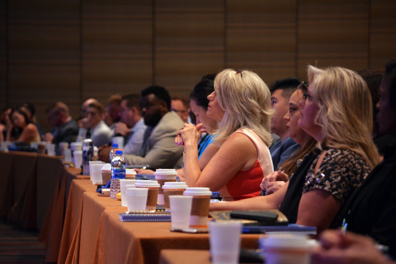 Diverse group of business professionals attentive during a conference session in a meeting room.